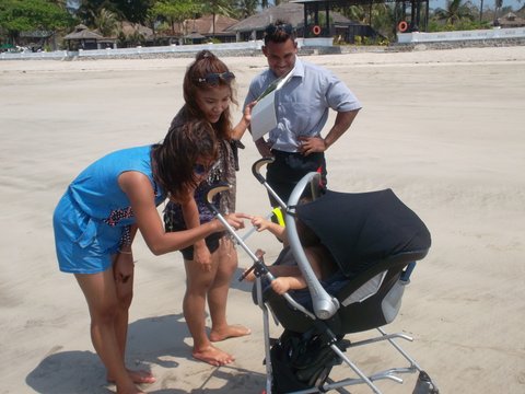 locals in Myanmar on beach with stroller